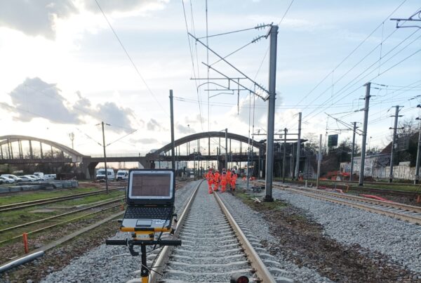 Equipe de géomètres prenant des mesures sur les voies du train pour le chantier du CDG Express.